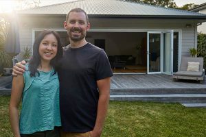 Couple standing in front of their new home