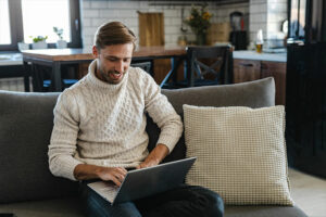 Man smiling while using laptop