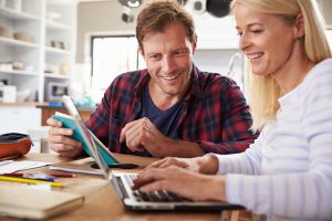 Happy couple looking at a laptop together