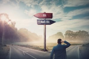 2 signs on a road reading IRA and Roth IRA