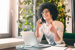 Man talking on the phone in front of a laptop