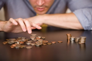 Man counting coins on tabletop