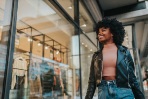 Woman walking past apparel store window