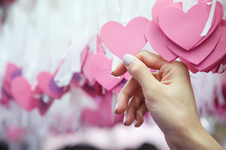 hand pulling at hanging pink hearts