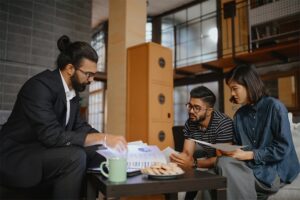 Group of 3 adults looking at documents together