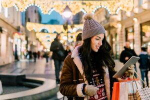 Woman wearing winter clothes while looking at tablet