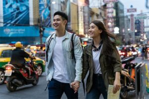 Smiling couple holding hands in city streets