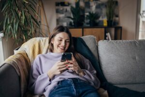 Woman smiling while using smartphone