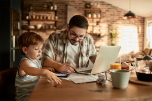 Father and son working together with laptop at a table