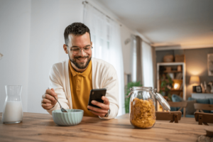 Adult man eating cornflakes with milk for breakfast.