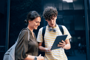Portrait of a Couple of Students Standing and Using the Digital Tablet.