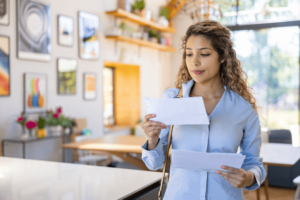 Woman arriving home and reading a letter in the mail.