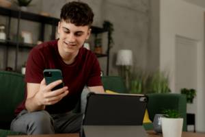 Happy man using mobile and working with his laptop.
