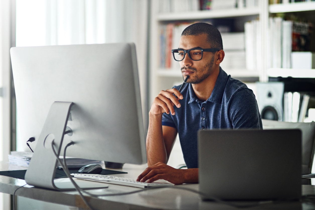 Man at a desk looking at his computer monitor